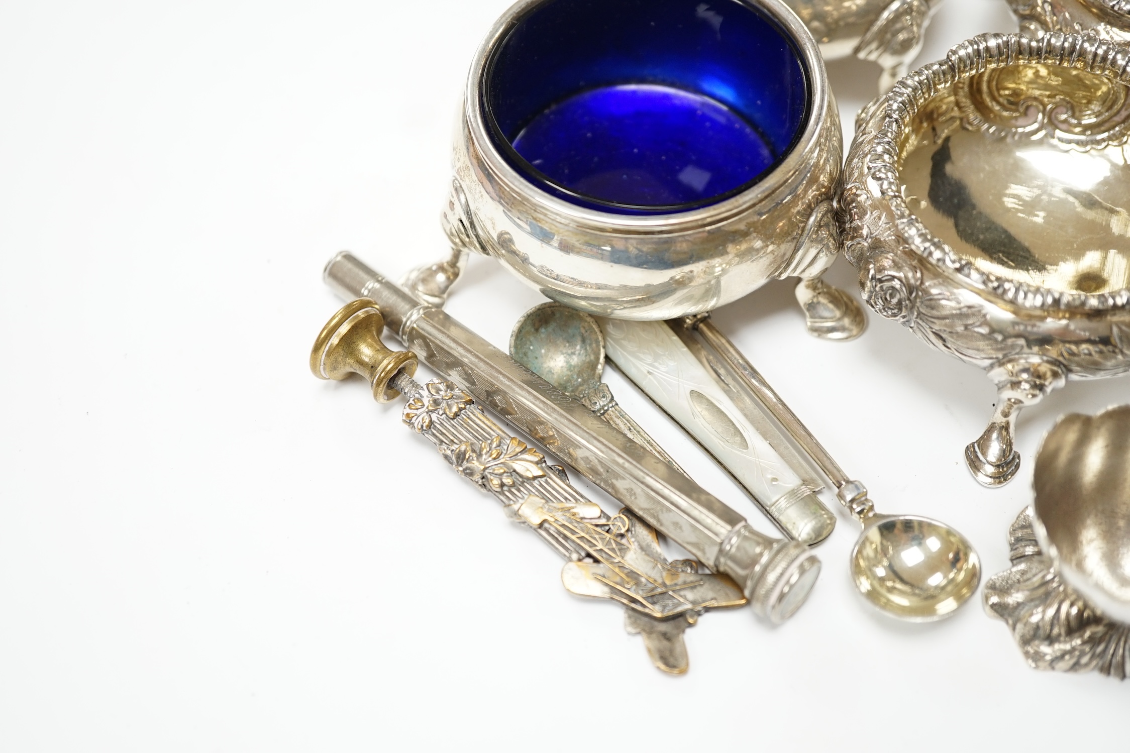 A pair of George II silver bun salts, London, 1735, diameter 60mm, a later pair of Victorian silver salts, a pair of Edwardian silver pepperettes by William Comyns and sundry other items including a circular silver vesta